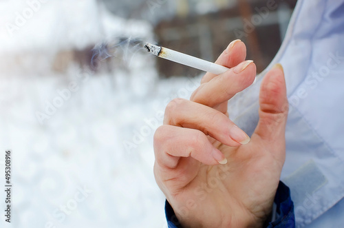 Smoking lit cigarette in hand  close-up. Bad habits  unhealthy lifestyle.