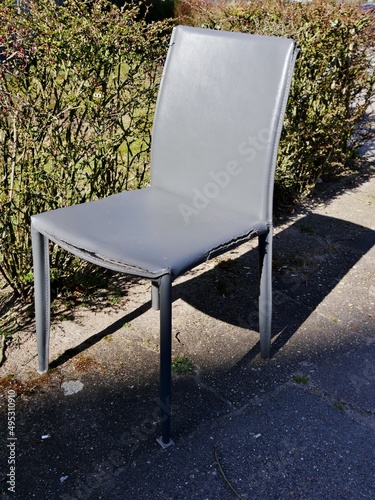 Kaputter Stuhl steht ausrangiert im Park photo