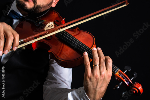 Hombre de vestimenta elegante tocando el violín en concierto photo