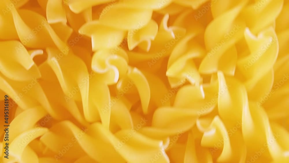 Uncooked Fusilli Pasta - Top View. Fat and Unhealthy Food. Dry Spiral Macaroni, Moving Background. Italian Culture and Cuisine. Raw Golden Pasta Pattern. Upward Movement