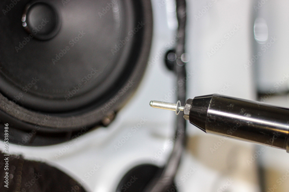 Rivet gun, applicator and rivets. Installing the speaker in the car. An