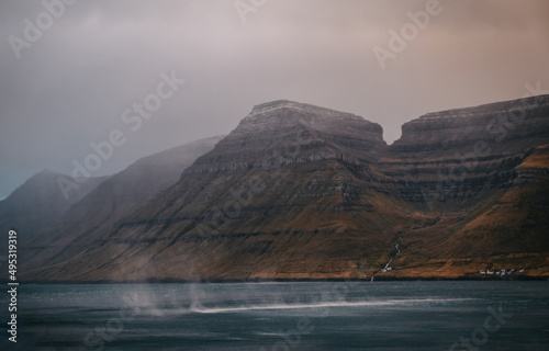 Faroe Islands  Kalsoy island near Husar village in sunset light durig twilight with pink sky and cliffs. November 2021
