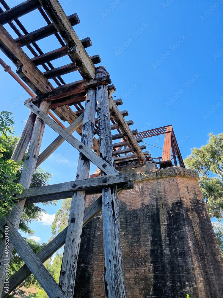 Old abandoned derelict railway bridge over Yass River Australia. Overgrown with trees Old abandoned derelict railway bridge over Yass River Australia. Overgrown with trees