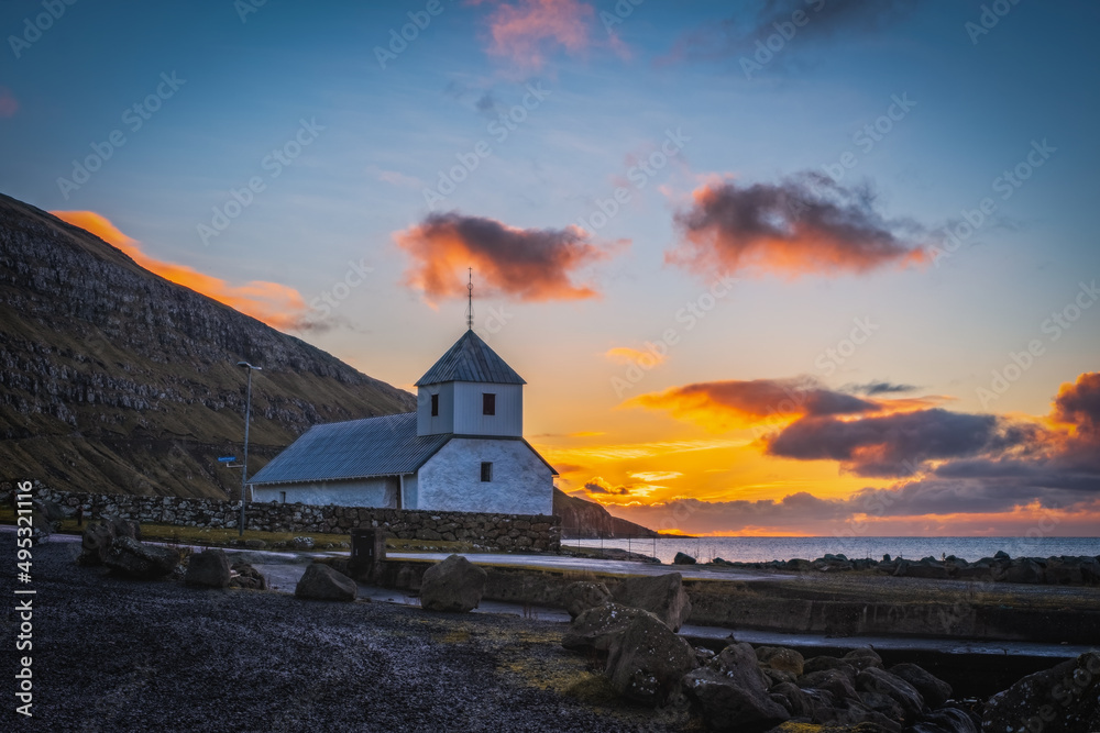 Fototapeta premium Stunning autumn view of medieval Olaf's Church in Kirkjubour village. Great sunrise in Faroe Islands, Denmark, Europe. Calm morning scene of Hestur Island. Traveling concept background. November 2021