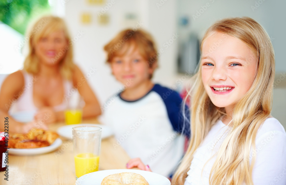 Smiling little girl with her family having breakfast. Portrait of a smiling little girl with her family having breakfast. Smiling little girl with her family having breakfast. Portrait of a smiling little girl with her family having breakfast.
