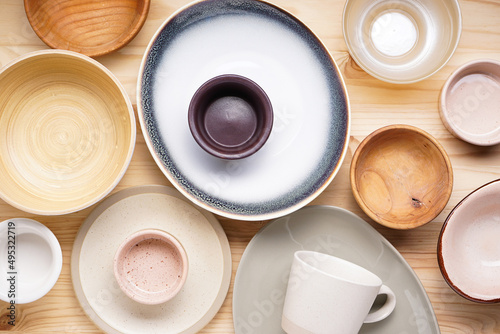 Modern ceramic and wooden crockery, trendy tableware. Dishes for serving and eating meals on a wooden background, top view.