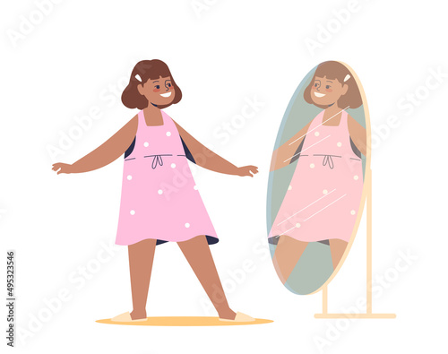 Happy girl in pink dress standing in front of mirror. Cute small kid dressing up, trying new clothes