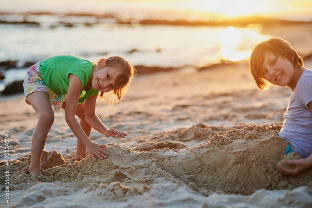 Were going to build the biggest sandcastle ever. Portrait of two young siblings playing together in the sand at the beach. Were going to build the biggest sandcastle ever. Portrait of two young siblings playing together in the sand at the beach.