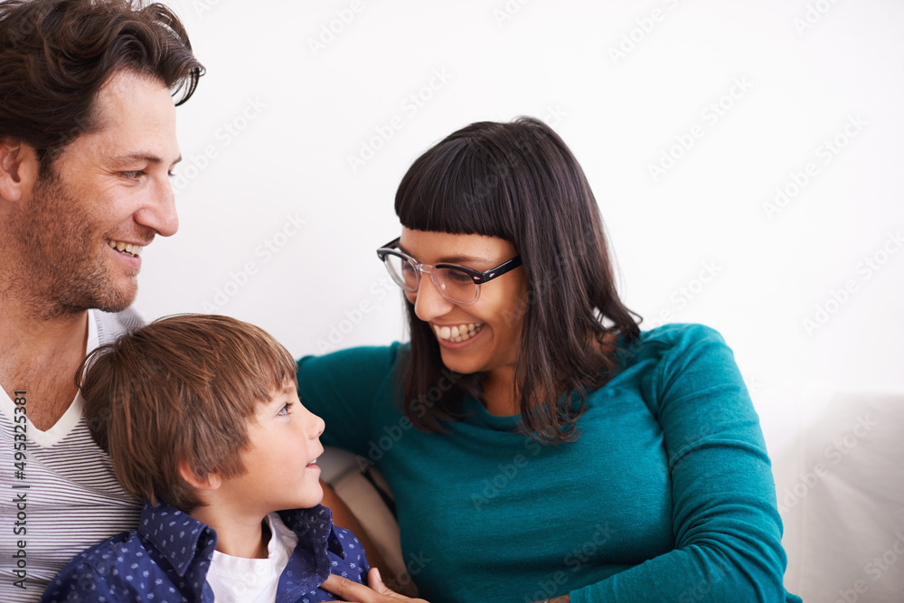Relaxing at home with mom and dad. Shot of a young family sitting on a couch. Relaxing at home with mom and dad. Shot of a young family sitting on a couch.