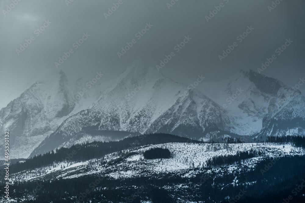 Obraz premium Tatry Wysokie o świcie, zima, szczyty w chmurach, Karpaty, widok z przełęczy nad Łapszanką.