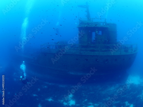 scuba divers exploring and discovering the ship wreck underwater deep sea bottom metal on ocean floor © underocean
