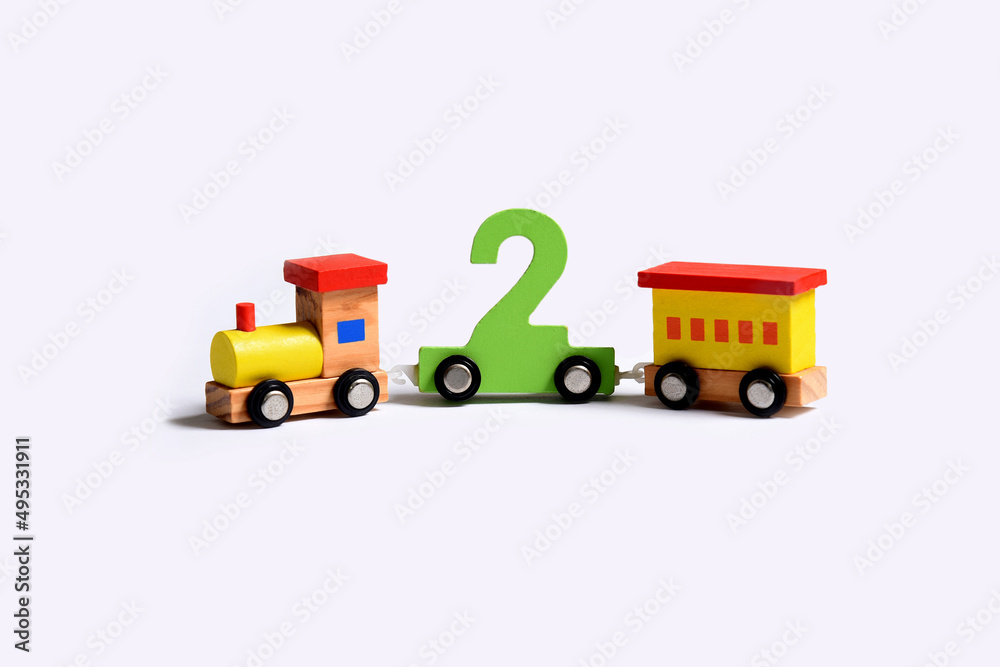 Very colorful toy wooden train that bears the number two . Birthday celebration love and happiness