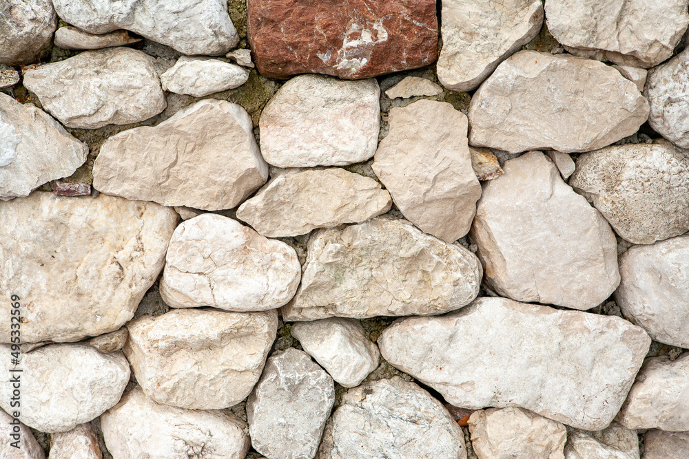 Fototapeta premium Panorama stone wall for background design. A backing with natural stones for branding, calendar, postcard, screensaver, wallpaper, poster, banner, cover, website. A place for your design or text