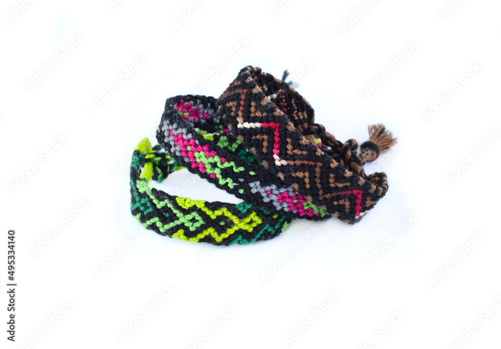 Tied woven friendship bracelets with bright colorful pattern handmade of thread isolated on white background Tied woven friendship bracelets with bright colorful pattern handmade of thread isolated on white background