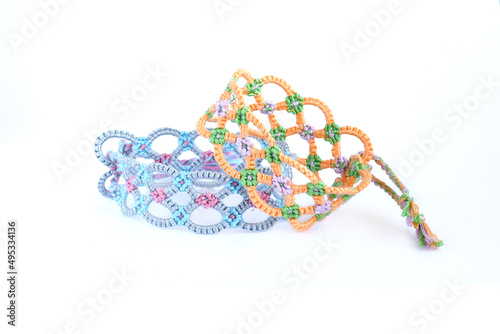 Tied woven friendship bracelets with bright colorful pattern handmade of thread isolated on white background