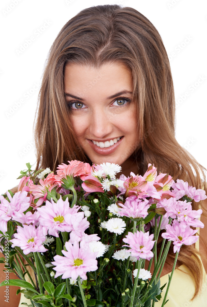 Almost as beautiful as her.... Studio shot of an attractive woman holding a bouquet of flowers.