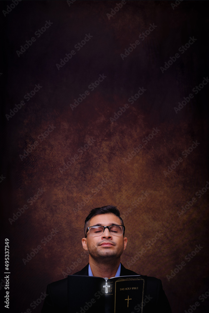 Christian man holding holy bilble with cross praying and worship to god