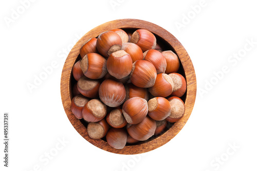 shelled forest nuts in wooden bowl isolated on white background. Vegan food, top view.