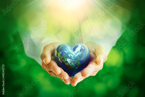 Fototapeta Naklejka Na Ścianę i Meble -  Earth crystal glass globe ball in Heart Shape in human hands,save clean planet,  World Earth Day Concept.