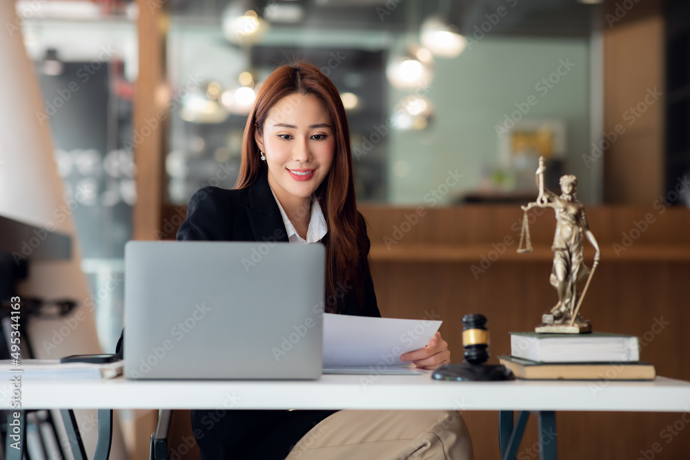 Attractive young lawyer in office Business woman and lawyers discussing contract papers with brass scale on wooden desk in office. Law, legal services, advice, Justice and real estate concept. Attractive young lawyer in office Business woman and lawyers discussing contract papers with brass scale on wooden desk in office. Law, legal services, advice, Justice and real estate concept.