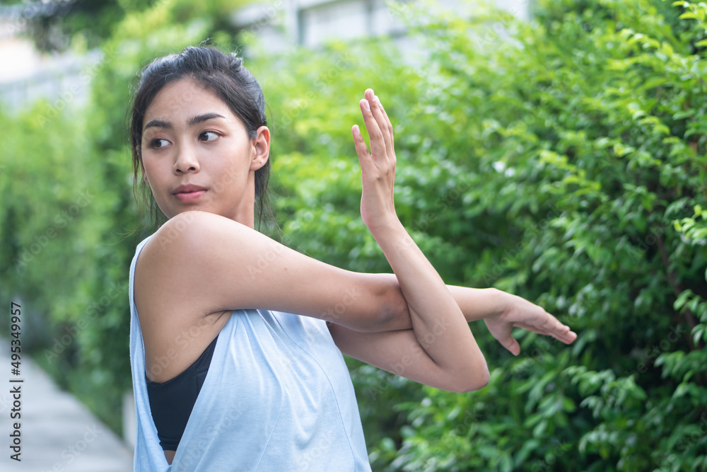 Woman practicing traditional yoga shoulder stretching pose series in city park, concept of self care, health care, mindfulness, wellness Woman practicing traditional yoga shoulder stretching pose series in city park, concept of self care, health care, mindfulness, wellness