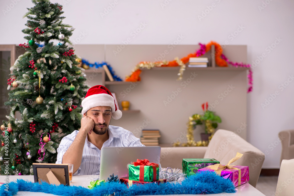 Young man celebrating Christmas at home alone Young man celebrating Christmas at home alone