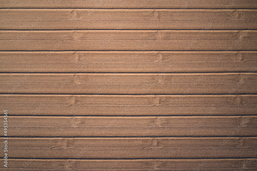 Smooth stripes on a dirt field Drone view. Arable land at high altitude. Plowed field aerial view. Perfect lines of brown plowed field top view. Smooth stripes on a dirt field Drone view. Arable land at high altitude. Plowed field aerial view. Perfect lines of brown plowed field top view.