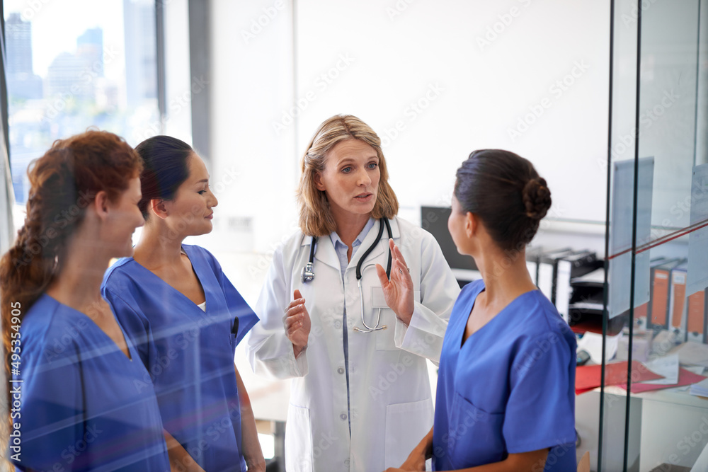 Giving them their instructions. Shot of a female doctor assigning tasks to a group of nurses at a hospital. Giving them their instructions. Shot of a female doctor assigning tasks to a group of nurses at a hospital.