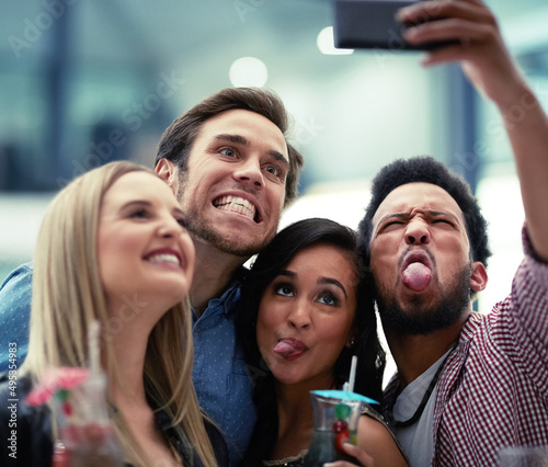 Making memories together. Shot of a happy group of friends taking a selfie with a smartphone in a nightclub.