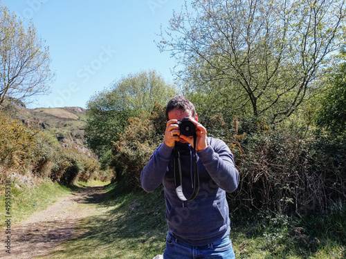 young man in foreground photographing with dslr photo camera