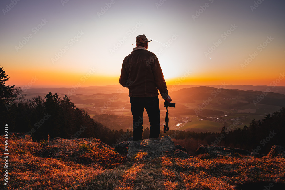 Photographer with camera in sunset taking photos of landscape. Travel Lifestyle hobby concept adventure active vacations outdoor