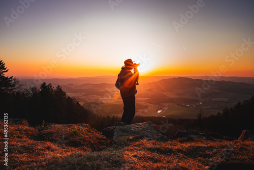 Photographer with camera in sunset taking photos of landscape. Travel Lifestyle hobby concept adventure active vacations outdoor © CreativeImage