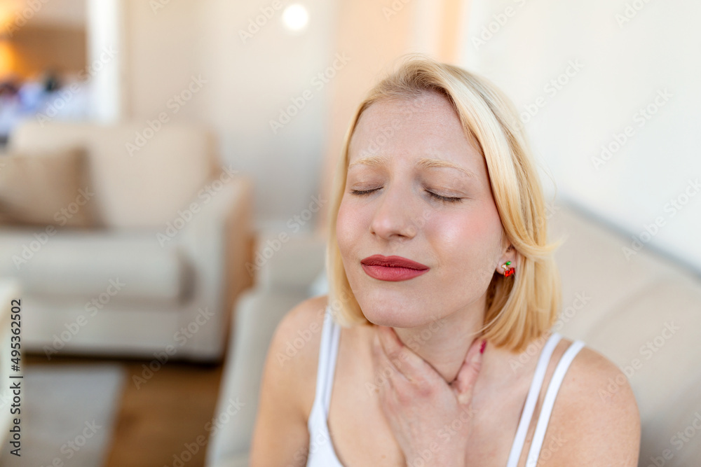 Close up of young woman rubbing her inflamed tonsils, tonsilitis problem, cropped. Woman with thyroid gland problem, touching her neck, girl has a sore throat Close up of young woman rubbing her inflamed tonsils, tonsilitis problem, cropped. Woman with thyroid gland problem, touching her neck, girl has a sore throat