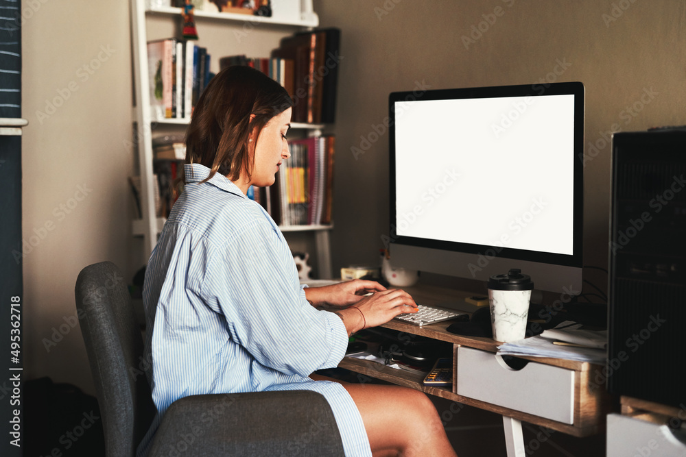 Working from home is my favourite. Cropped shot of an attractive young businesswoman sitting alone in her home office and using her computer.
