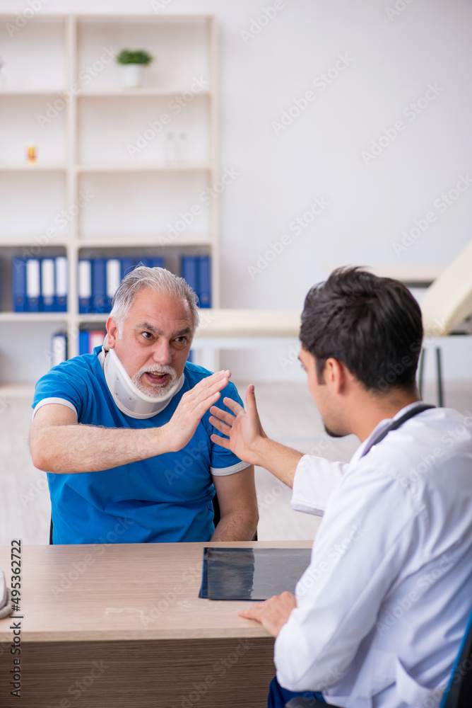 Old neck injured male patient visiting young male doctor Old neck injured male patient visiting young male doctor