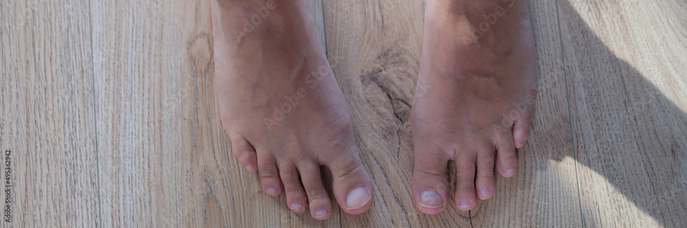 Feet of female legs, close-up. Standing barefoot on the floor Feet of female legs, close-up. Standing barefoot on the floor