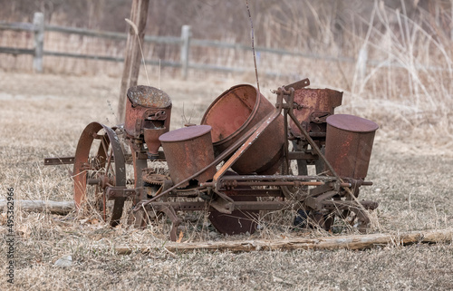 Old rusty abandoned farm equipment in Michigan countryside.