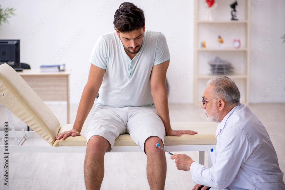 Young male patient visiting old male doctor neurologist Young male patient visiting old male doctor neurologist