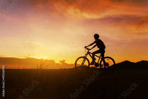 Cyclist woman doing selfie and happy riding mountain bike after covid-19 coronavirus outbreak. End of the coronavirus outbreak. Silhouette cycling woman riding mountain bike at sunset time.