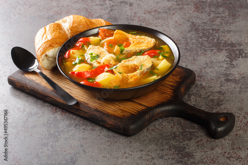 Portuguese Traditional Fishermans Stew Caldeirada De Peixe close-up in a bowl on the wooden board. Horizontal photo