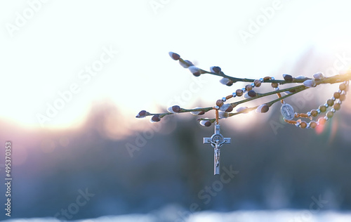 christianity cross and willow branches  against blurred sunny natural background. Easter holiday, Orthodox palm Sunday. Symbol of Christianity, Lent, Faith in God, Church holiday. spring season
