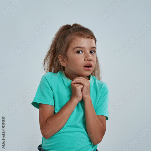 Shocked girl with open mouth and clasped hands