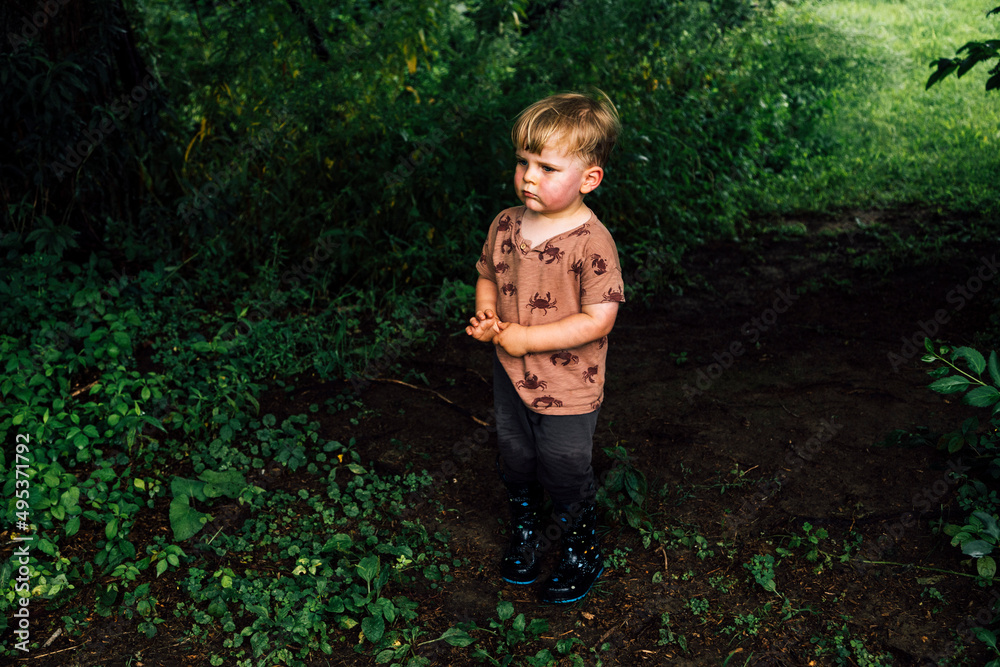 Boy wearing rubber boots standing in park Boy wearing rubber boots standing in park