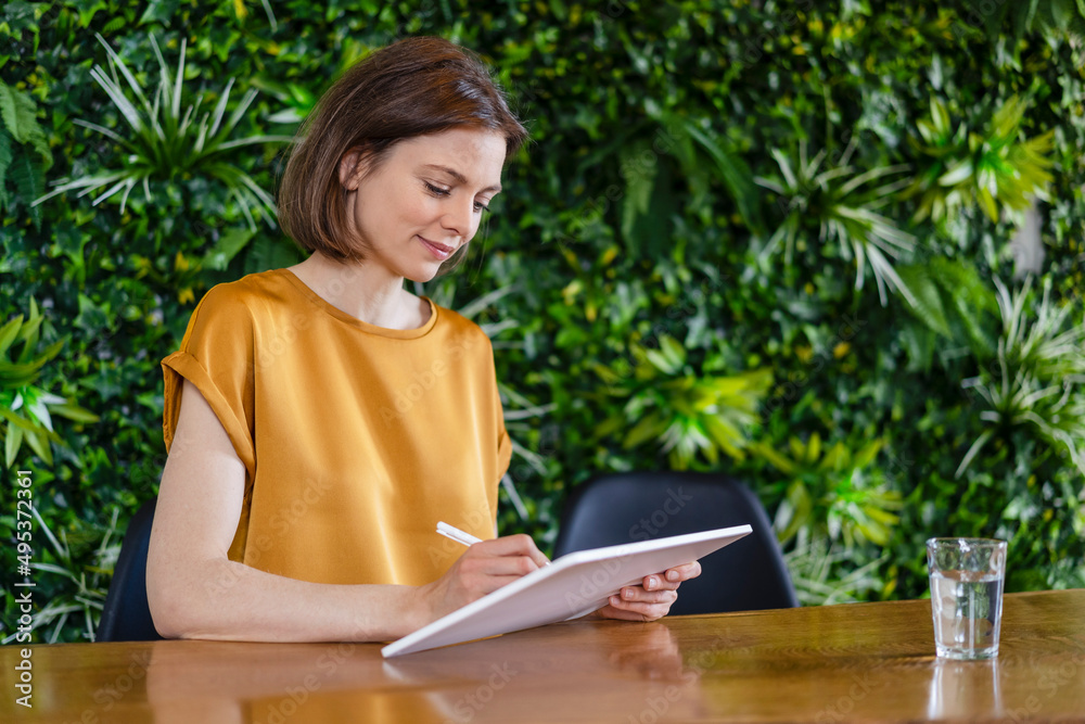 Smiling freelancer working with tablet PC at home office Smiling freelancer working with tablet PC at home office