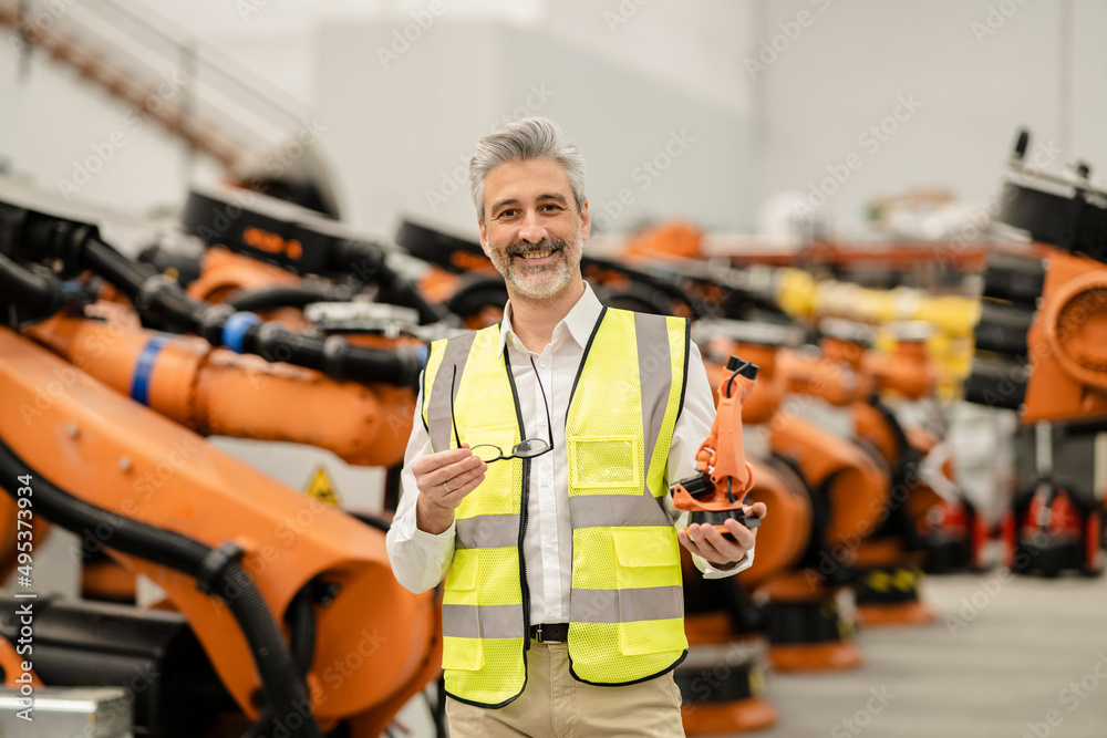 Engineers Crocs Smiling engineer holding model of robotic arm and eyeglasses standing ...