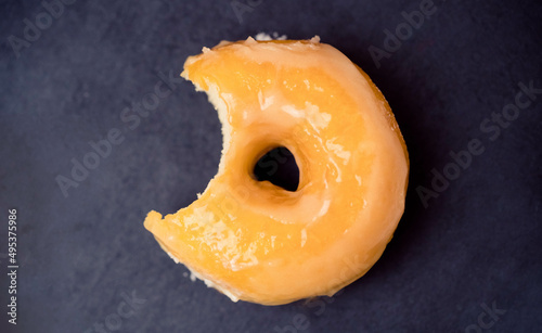 classic glazed donut.Flat lay donut on black plate.sweet doughnut dessert bakery.Unhealthy tasty donut.bakery menu.Bite eat bakery, diet, calories, sugar.