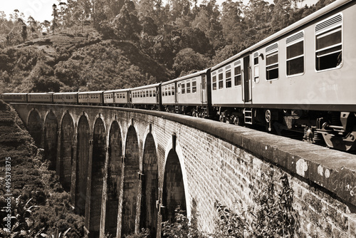 Sepia toned photo of train running on the Nine Arch Bridge, Demodara, Sri Lanka