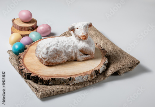 Traditional easter sweet lamb cake with powdered sugar, eggs, wood and sack on white background, stock photo 
