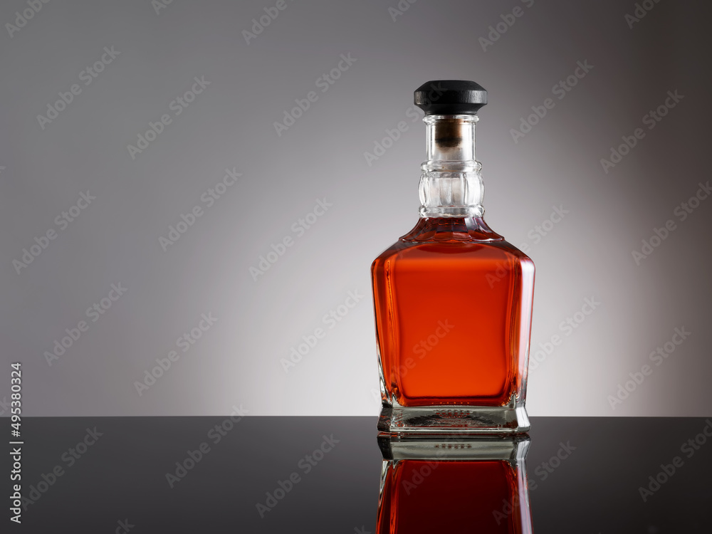 Classy elegant whiskey bottle on a black reflective bar counter surface. Classy elegant whiskey bottle on a black reflective bar counter surface.