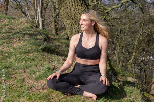 Woman practicing yoga outdoors in woodland